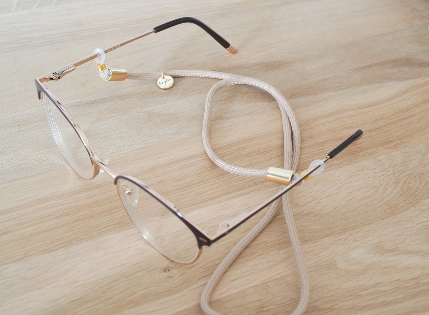 Brillenband aus beigefarbenem Tau und goldenen Details