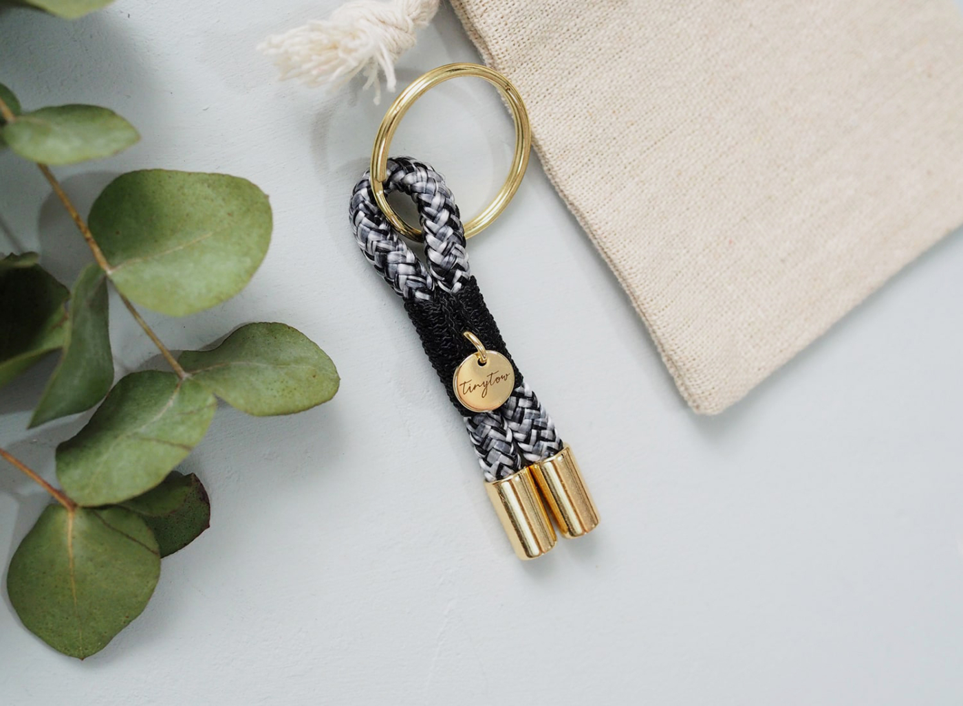 Schlüsselanhänger aus Tau mit schwarz-weißem Tauseil, schwarzer Takelung und goldenen Details.